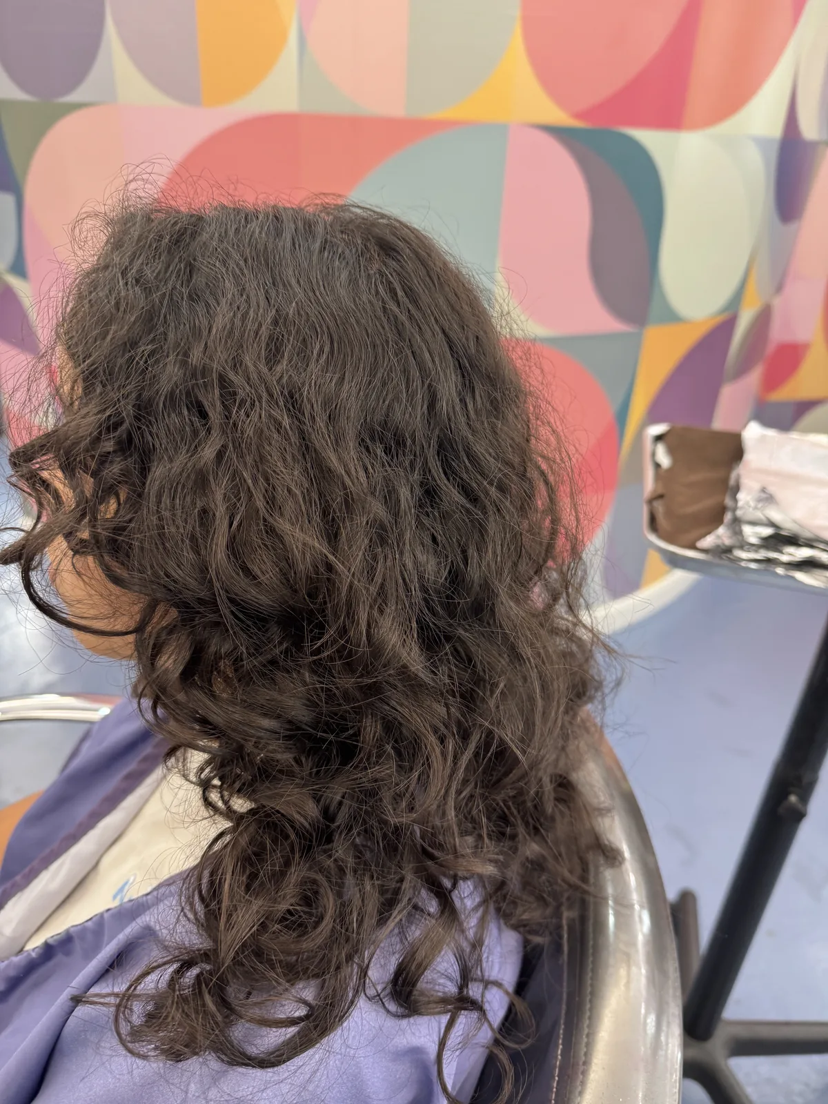 Before anti-frizz smoothing treatment: curly brunette hair with frizz and volume, at Beyond Salon in Condado, San Juan