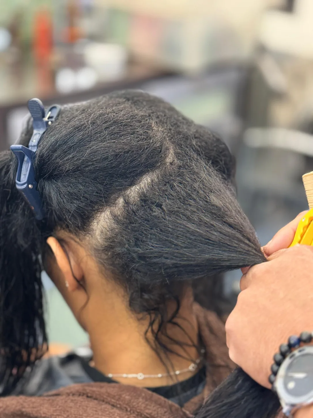 During an anti-frizz smoothing treatment: hair divided into clipped sections, worked one section at a time at Beyond Salon in Condado